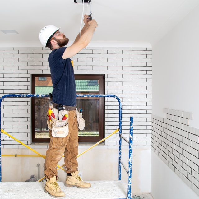 Professional in overalls with tools on the background of the repair site. Home renovation concept.